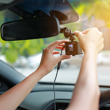 a driver holding a dash cam